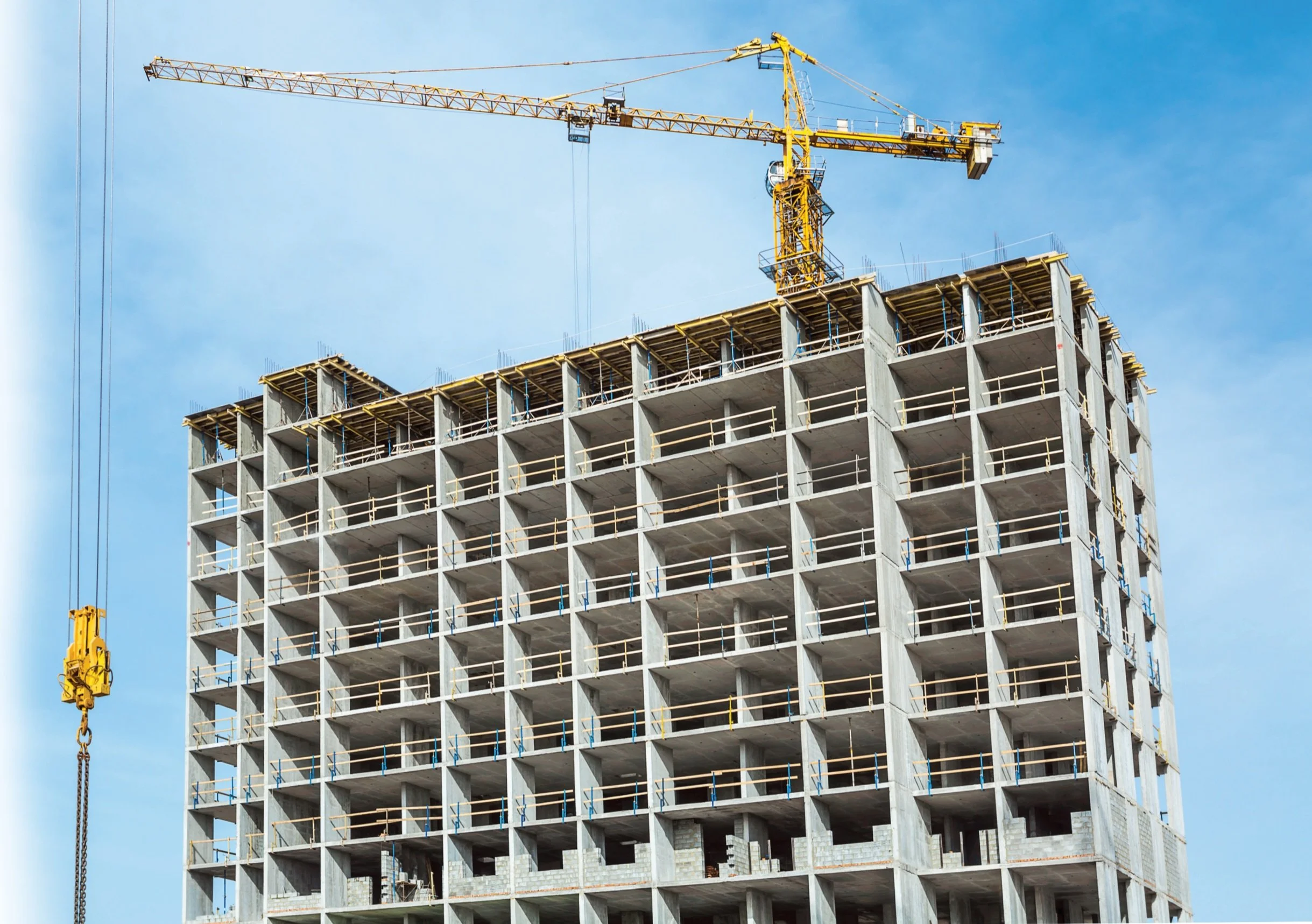 A tower crane over a concrete structure under formwork against the sky — MJF formwork carpentry